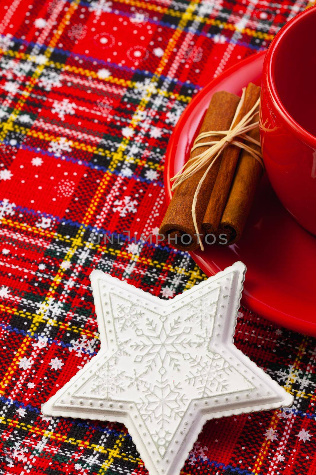 Photo of red cup of coffee, cinnamon and placemats. Near diary red cup Christmas white star.  Winter holidays. Merry christmas and happy new year concept.