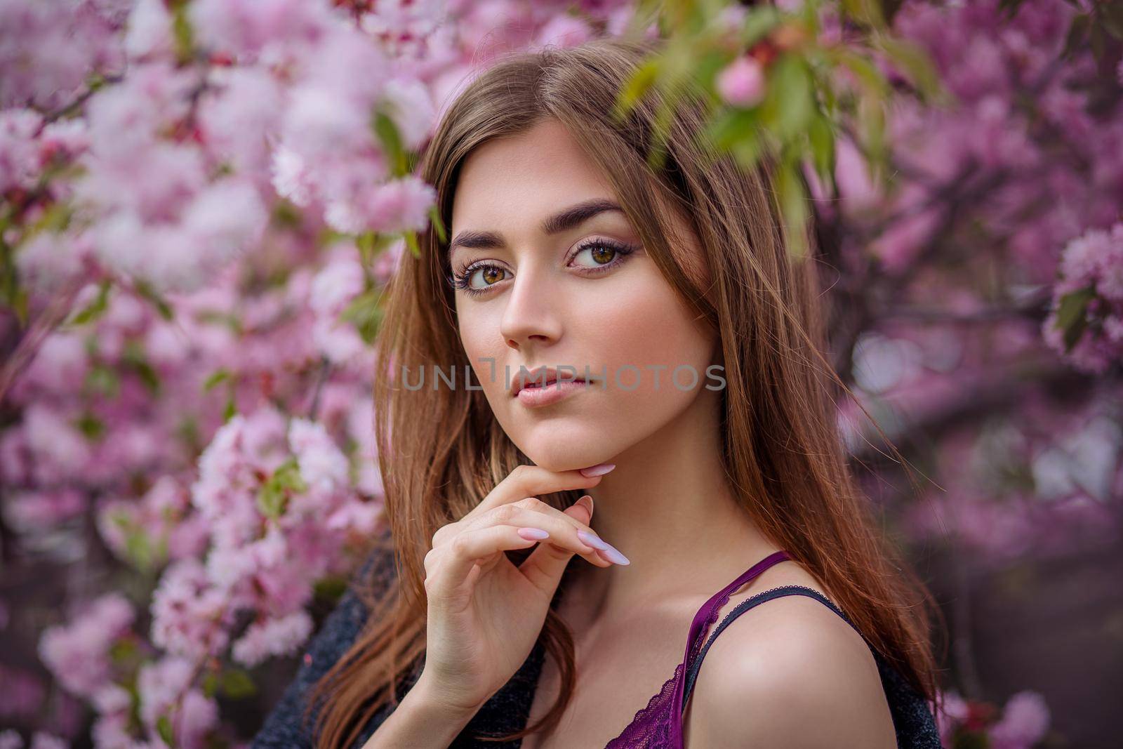 beautiful young woman in blooming cherry blossoms garden in early spring