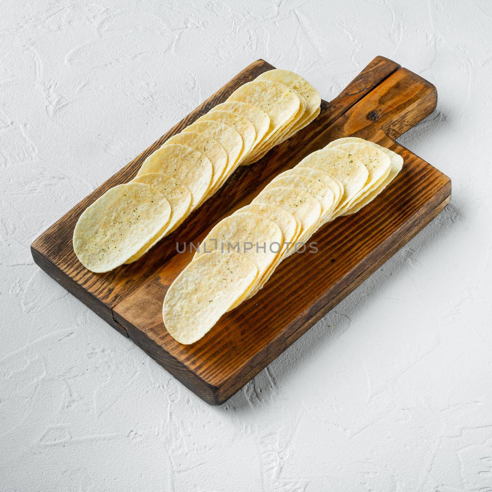 Salty potato chips snack , on white stone surface by Ilianesolenyi