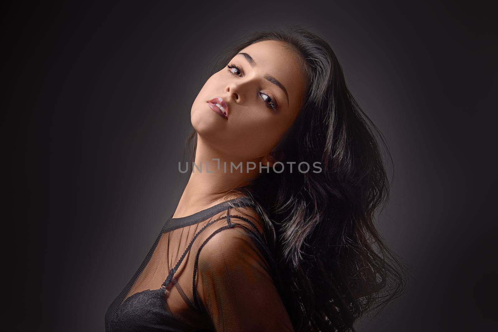 Portrait fashionable young woman in studio on black background
