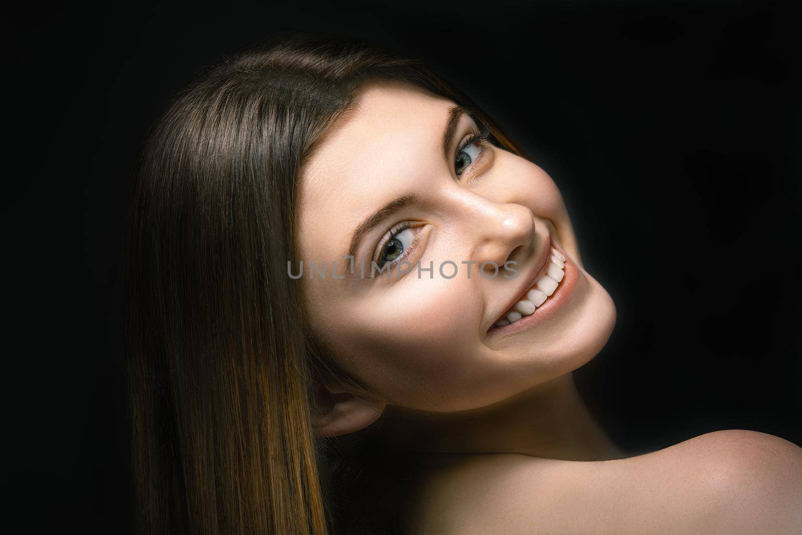 Portrait smiling young woman in studio on black background. Youth concept