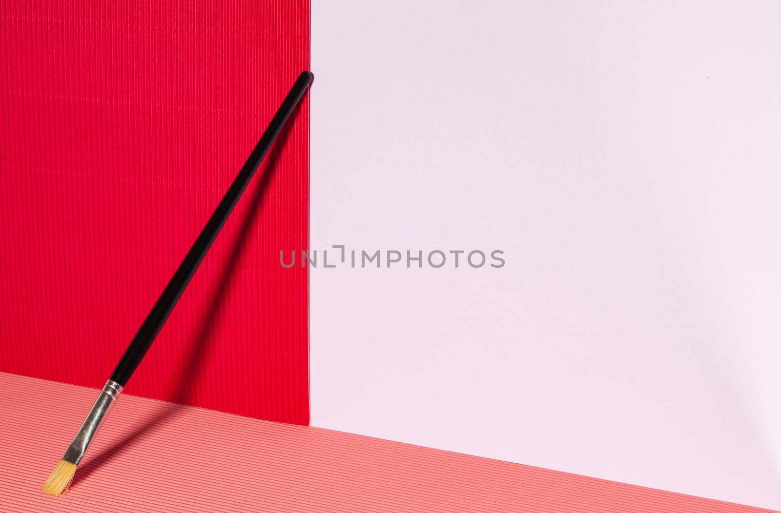 Still life in artist studio with paint brush and red paper by CaptureLight