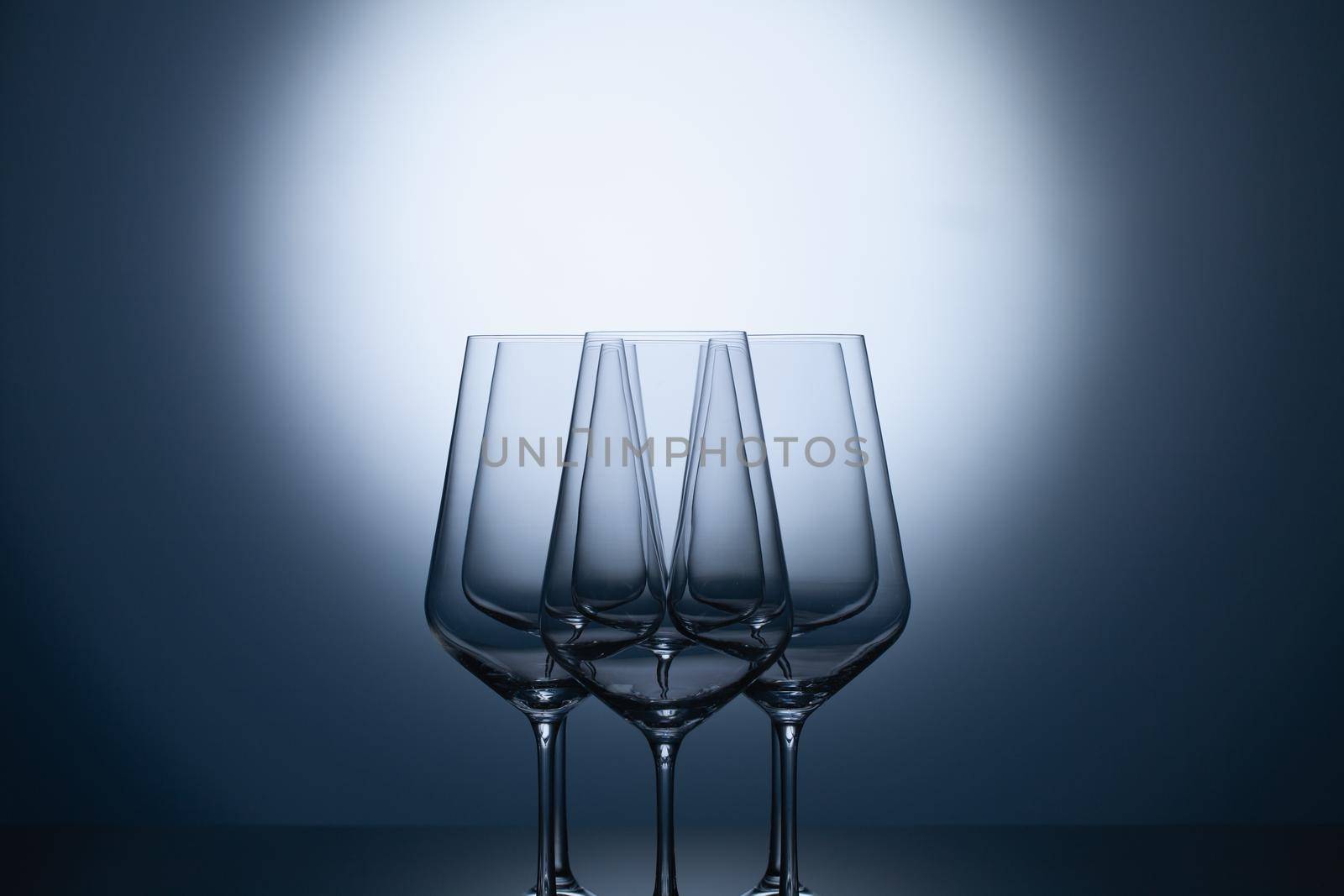 Empty wine glasses on a blue clean gradient background.  by CaptureLight
