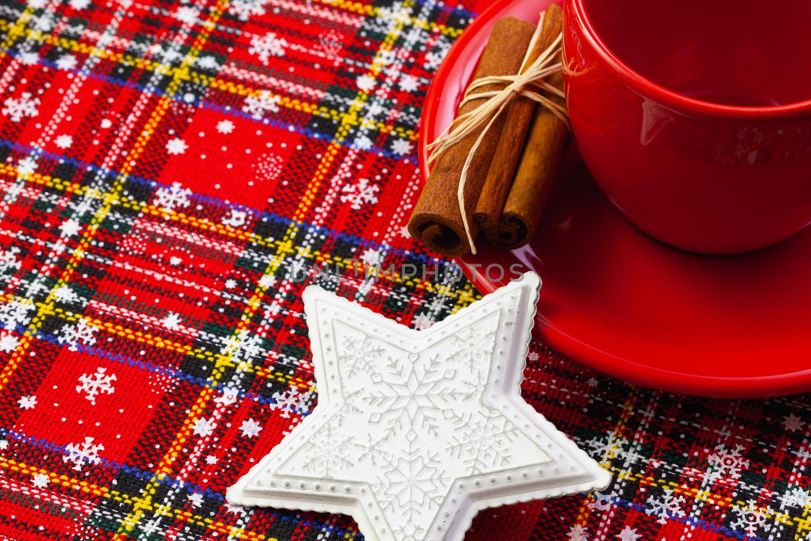 Photo of red cup of coffee, cinnamon and placemats. Near diary red cup Christmas white star.  Winter holidays. Merry christmas and happy new year concept.