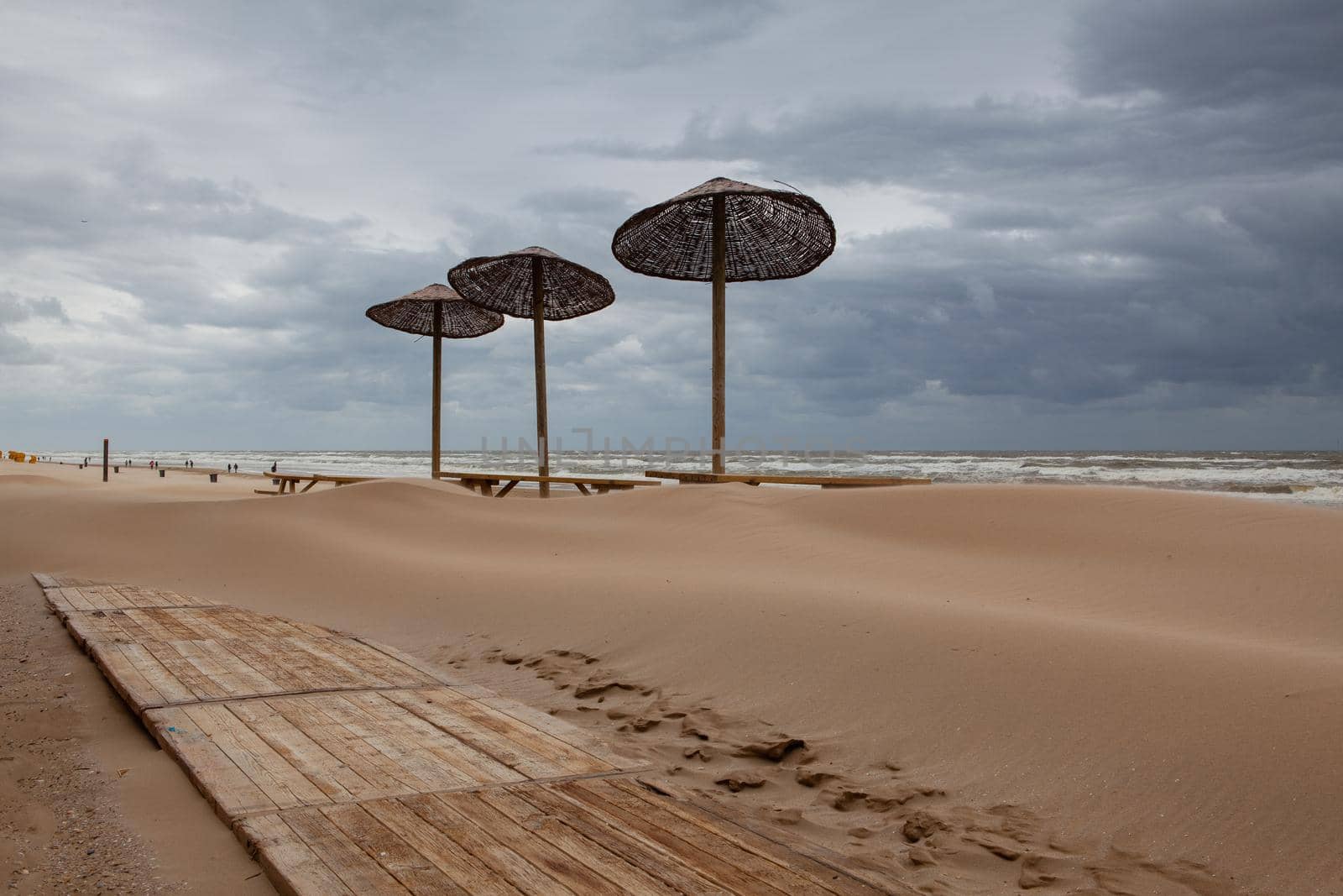 The sand-covered tables on the beach in Egmont aan Zee, Netherlands.  by CaptureLight