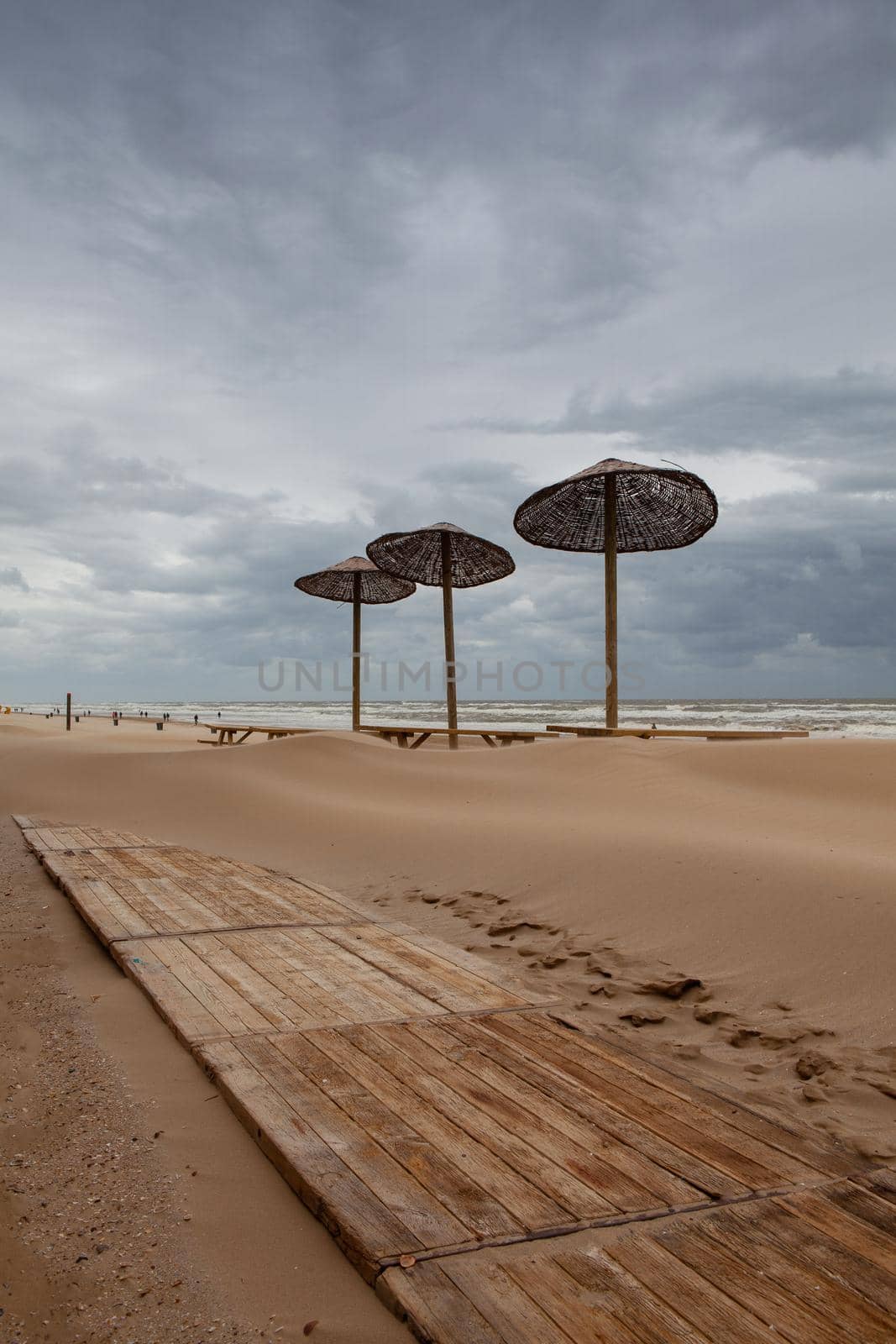 The sand-covered tables on the beach in Egmont aan Zee, Netherlands.  by CaptureLight
