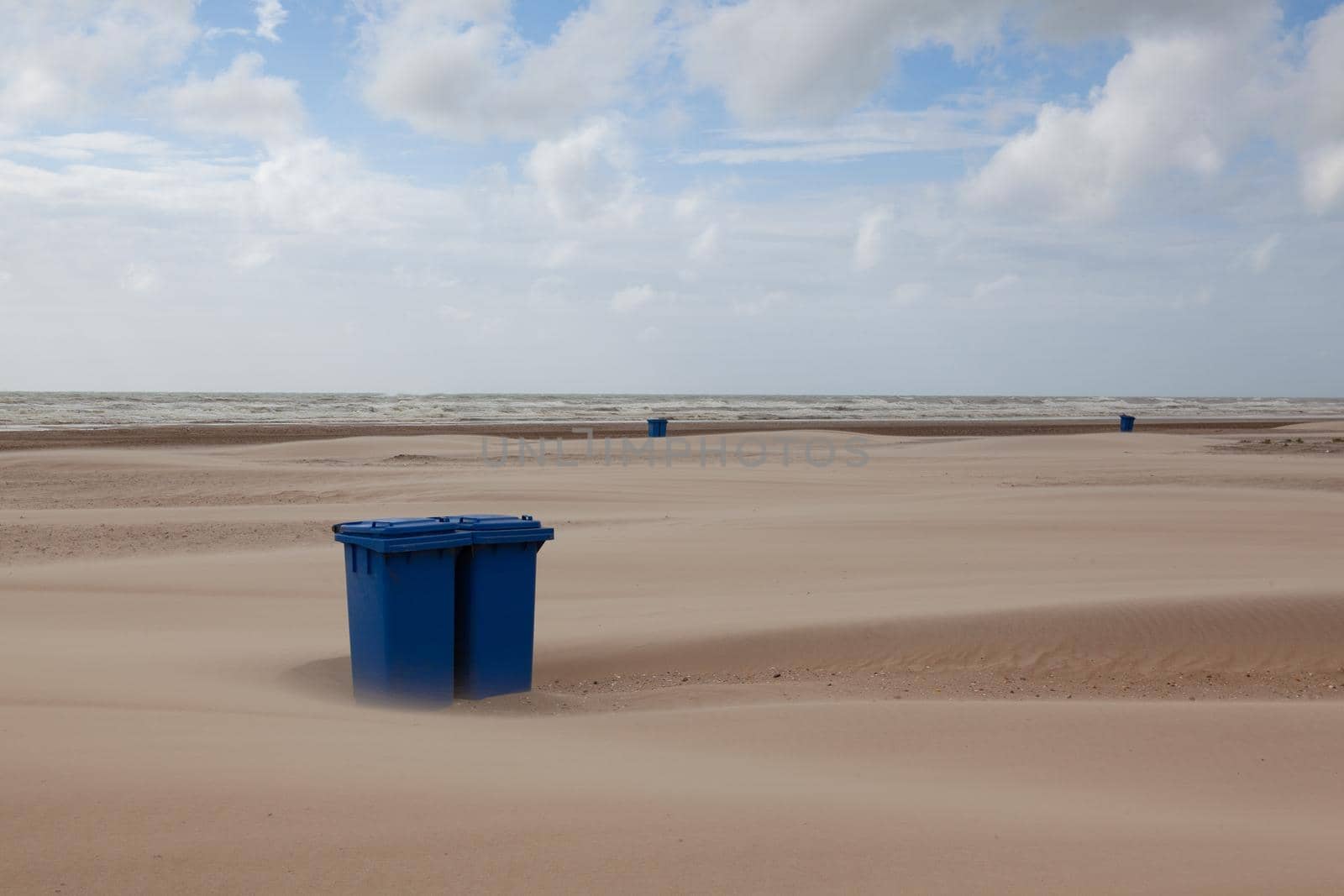 Sand covered trash can on the empty beach. The beach in Hargen aan Zee in Netherlands without foreign tourists after the coronavirus pandemic.