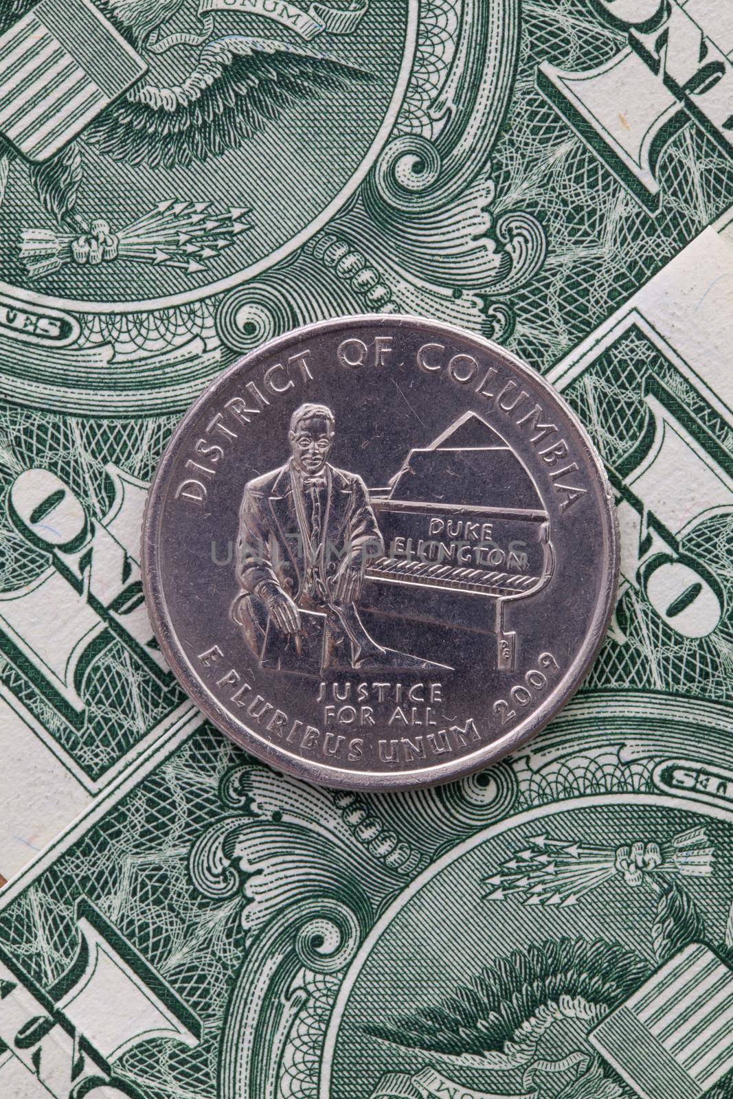 A quarter of District Of Columbia on US dollar bills. Symmetric composition of US dollar bills and a quarter of District Of Columbia.