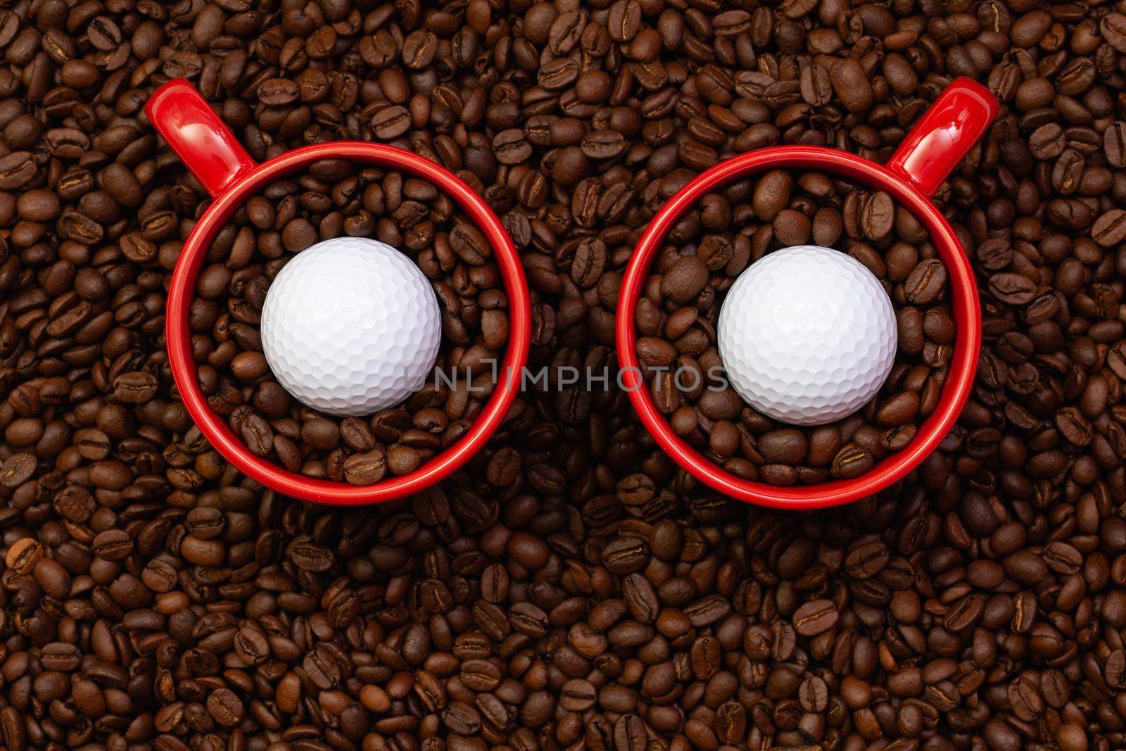 Two red cups full of coffee beans and one golf ball.  Fair Trade. Commodity trade. Fresh coffee beans. Funny owl.