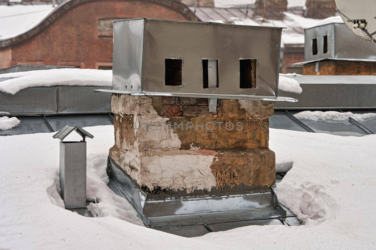 Old brick chimney on the roof covered with snow by vizland