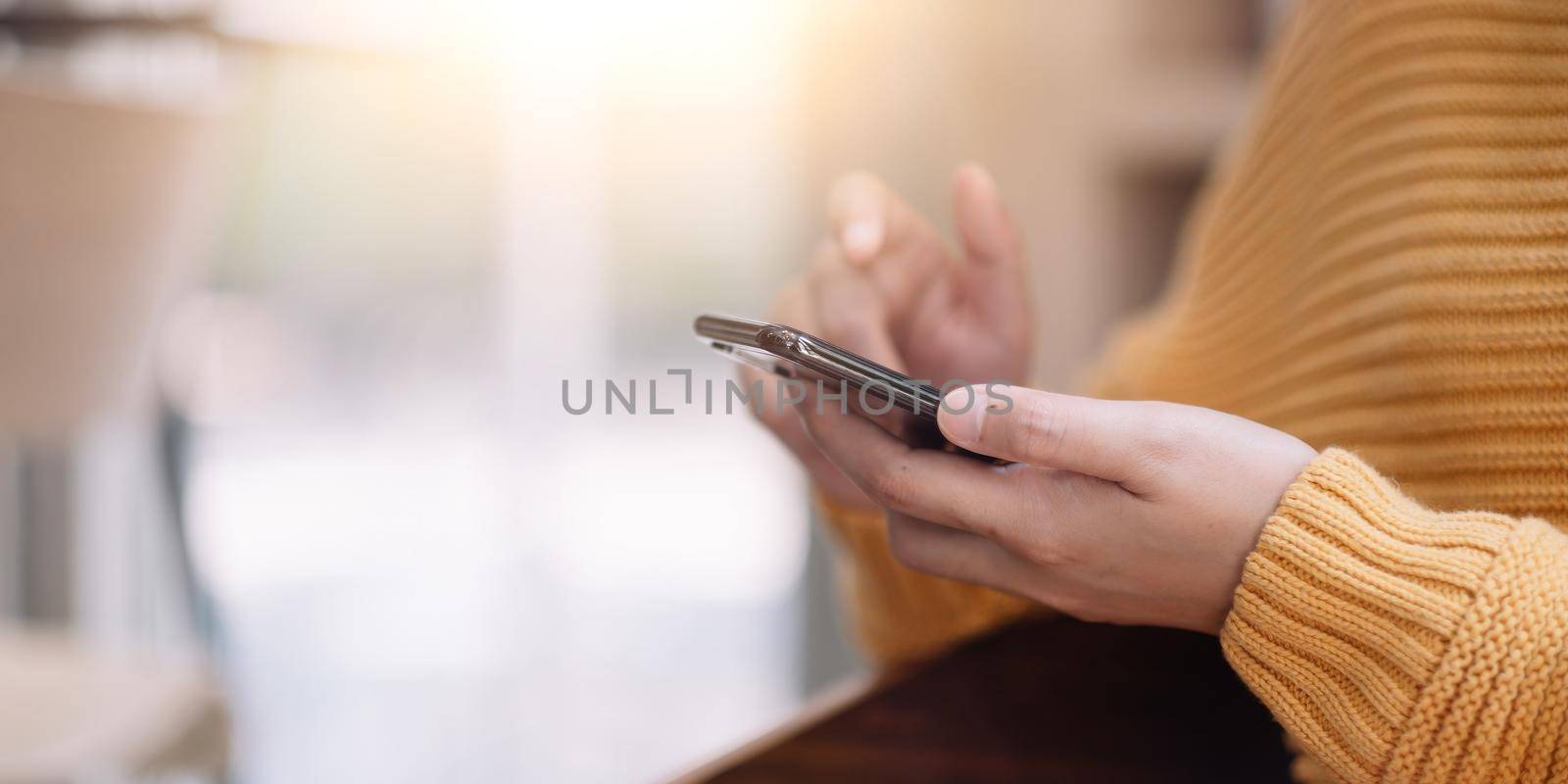 Close up hanf of woman using mobile phone. Isolation at home by nateemee