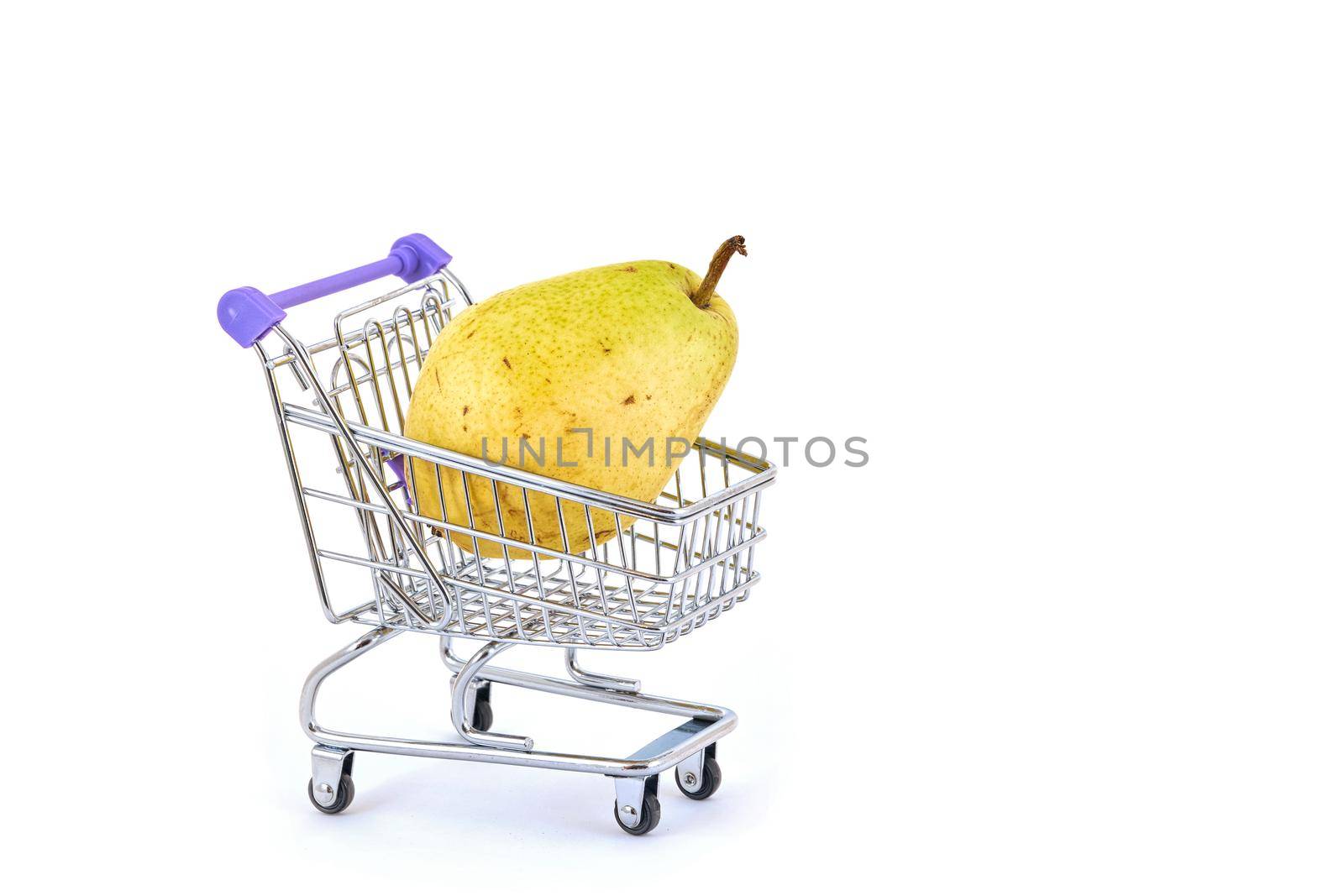 Beautiful ripe pear lies in a shopping cart isolated on a white background. Conceptual image