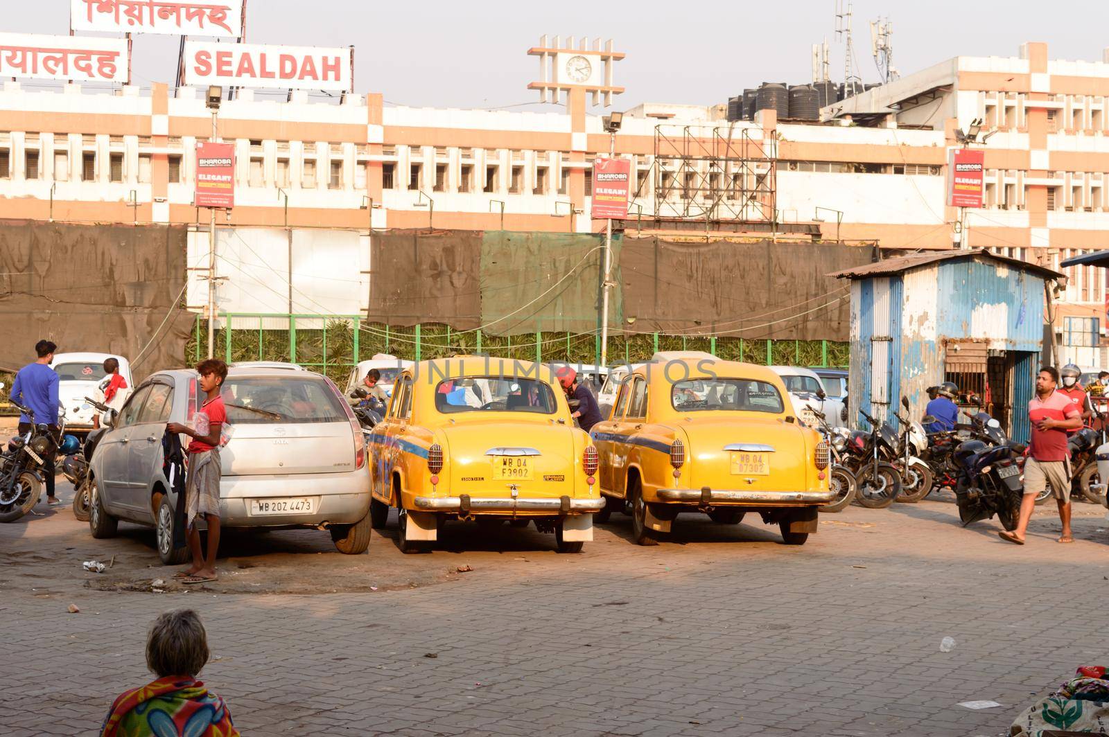 Kolkata's yellow Ambassador car cabs parked in the prepaid taxi booth outside Sealdah station platform main entrance gate. Sealdah Railway station Building Exterior, Kolkata, India, 8 March 2021 by sudiptabhowmick