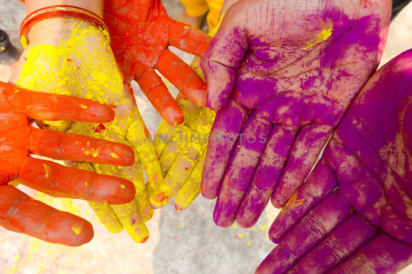 Young people with colorful powder in hands at holi festival in India celebrated with different colors. Holi hands, colorful hands illustration. Close up view. by sudiptabhowmick