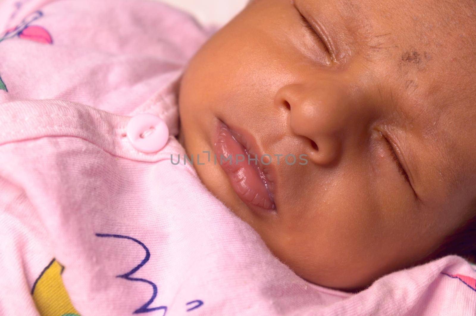 Extreme Close up face of a cute sleeping newborn baby. Closeup portrait of a Sweet One month old infant baby boy captured in sleepy mood. Front view. Child care kid background image. by sudiptabhowmick