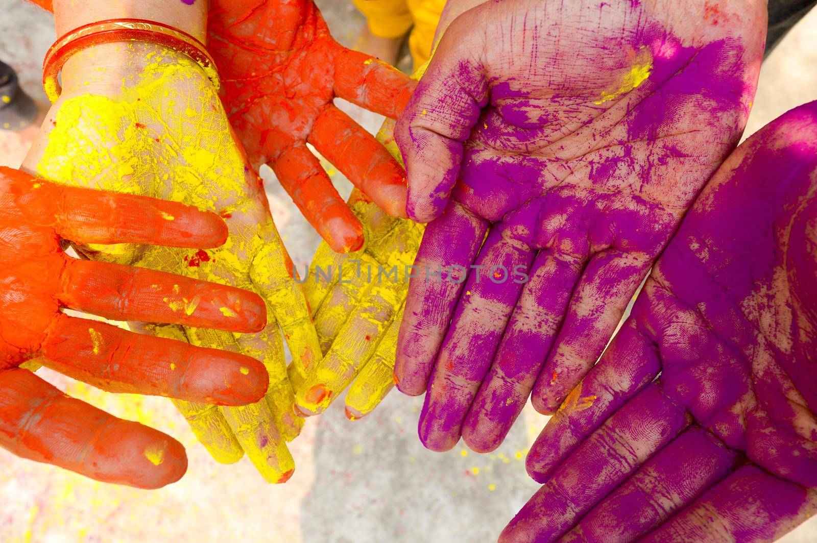 Young people with colorful powder in hands at holi festival in India celebrated with different colors. Holi hands, colorful hands illustration. Close up view. by sudiptabhowmick