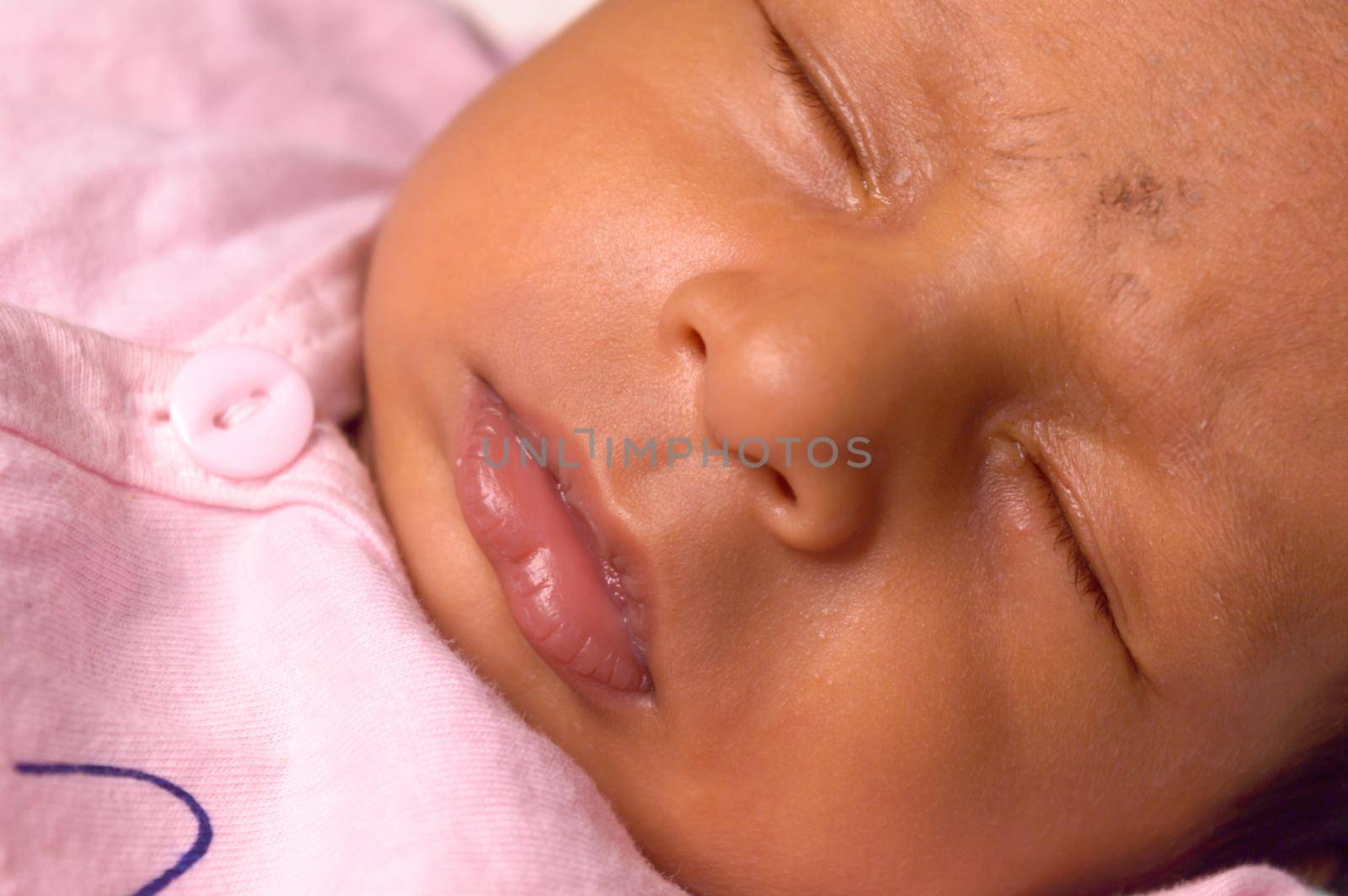 Extreme Close up face of a cute sleeping newborn baby. Closeup portrait of a Sweet One month old infant baby boy captured in sleepy mood. Front view. Child care kid background image.