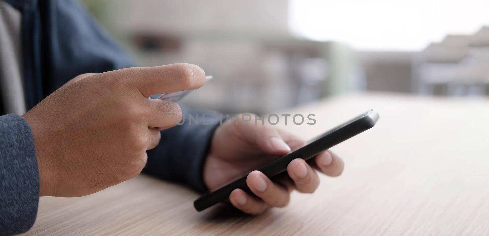 Online payment,Man's hands holding a credit card and using smart phone for online shopping.