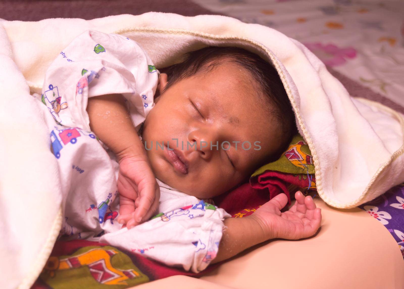 Close up face of cute sleeping newborn baby boy in drowsy eyes with sleepy mood. One month old Sweet infant toddler Closeup portrait. Indian ethnicity. Front view. Child care peace tranquil background