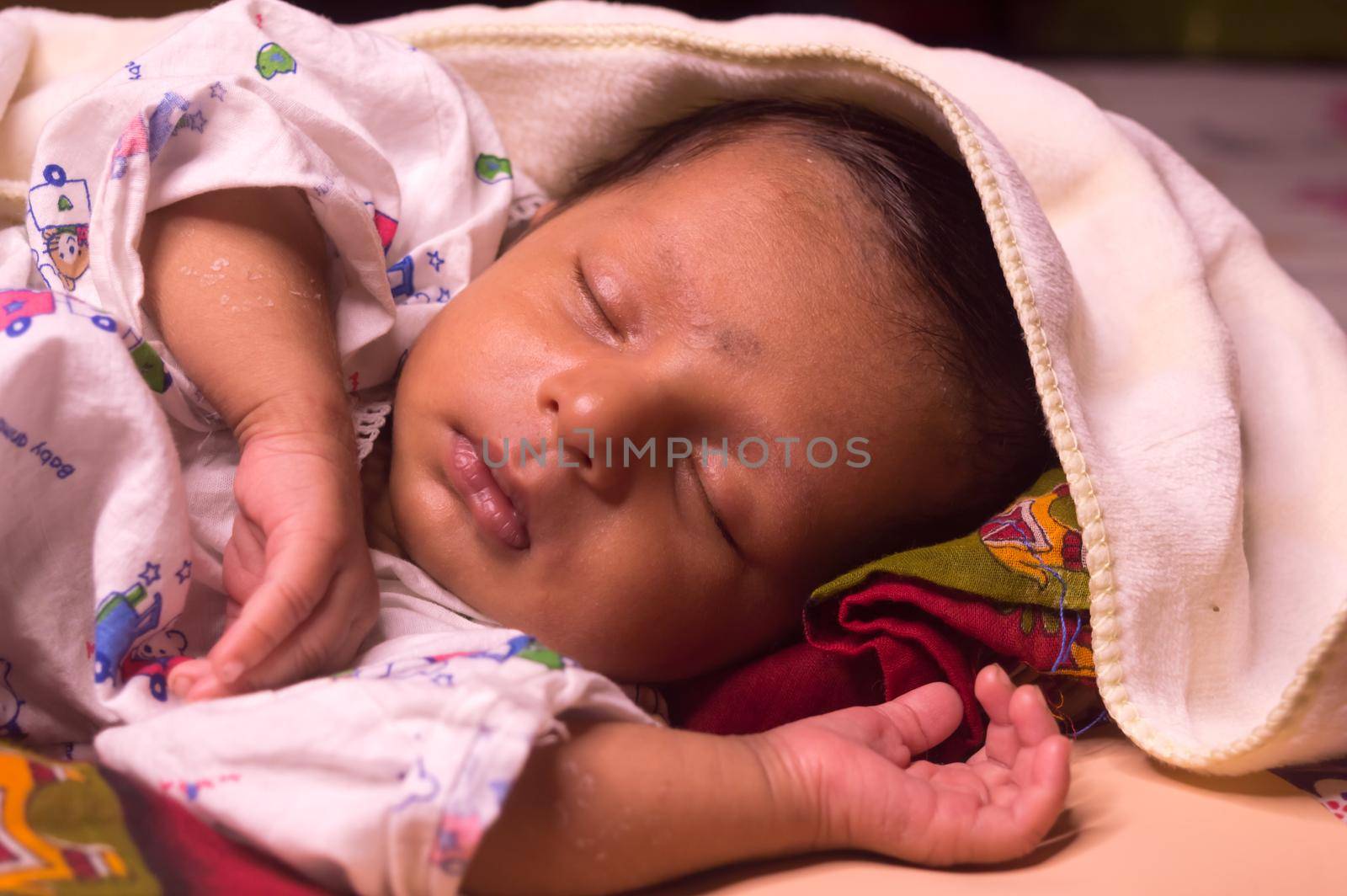 Close up face of cute sleeping newborn baby boy in drowsy eyes with sleepy mood. One month old Sweet infant toddler Closeup portrait. Indian ethnicity. Front view. Child care peace tranquil background