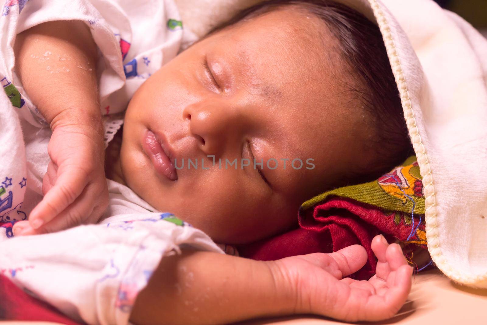 Close up face of cute sleeping newborn baby boy in drowsy eyes with sleepy mood. One month old Sweet infant toddler Closeup portrait. Indian ethnicity. Front view. Child care peace tranquil background by sudiptabhowmick