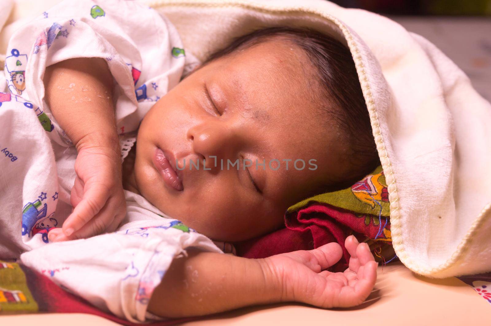 Close up face of cute sleeping newborn baby boy in drowsy eyes with sleepy mood. One month old Sweet infant toddler Closeup portrait. Indian ethnicity. Front view. Child care peace tranquil background