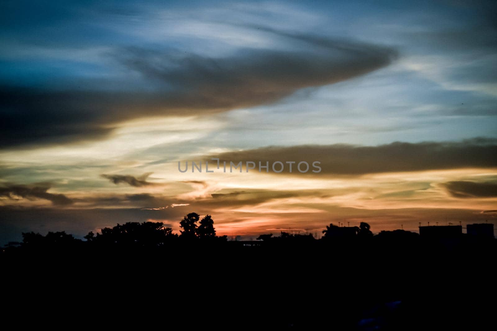 Sunset sky background. Multi color clouds-cape in sunset sky at dusk. Dramatic atmospheric mood. Landscape Beauty in nature horizon. by sudiptabhowmick