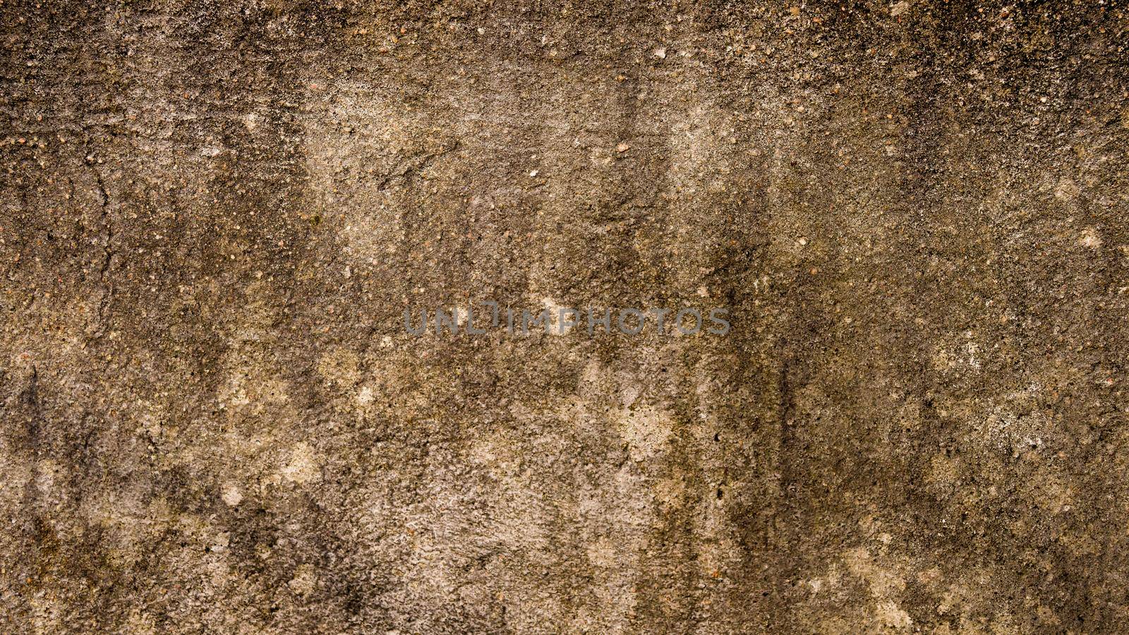 Moist Damp patch on Sand wall due to Rain penetration. Grunge crack moist concrete sand wall texture Pattern Background design element. Close up. Natural grungy color shade with minor uneven cracks. Sandy effects on building exterior plaster pillar.