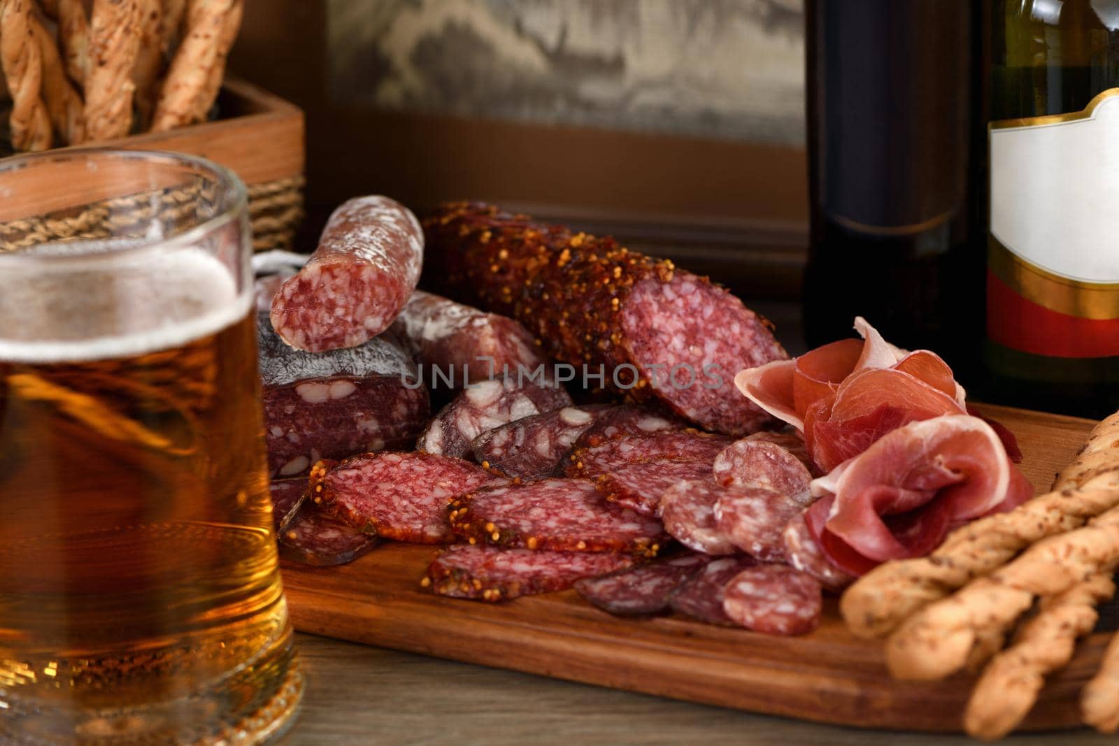 Antipasti dish with bacon, jerky, salami, crispy grissini with cheese. A meat appetizer is a great idea for a beer.