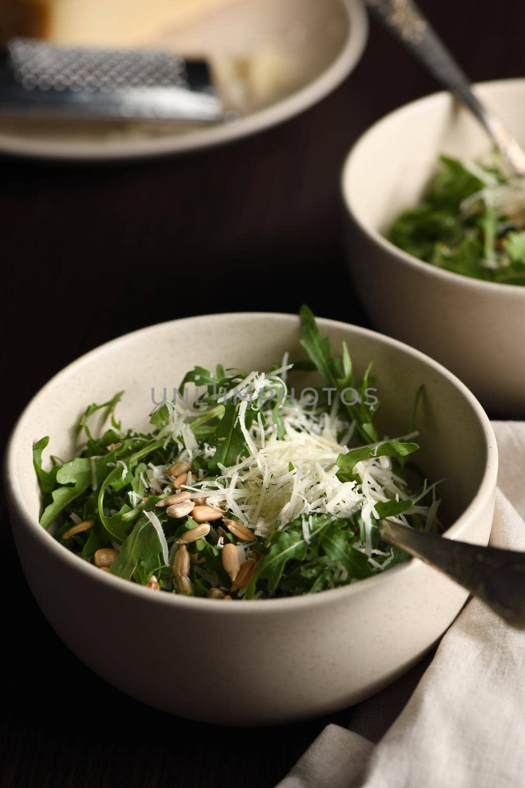 Arugula salad with sunflower kernels and sprinkled with grated parmesan
