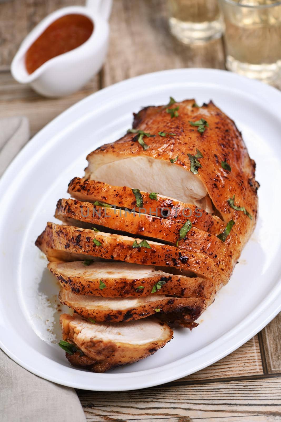 Sliced into slices baked turkey breast close-up at the dinner table