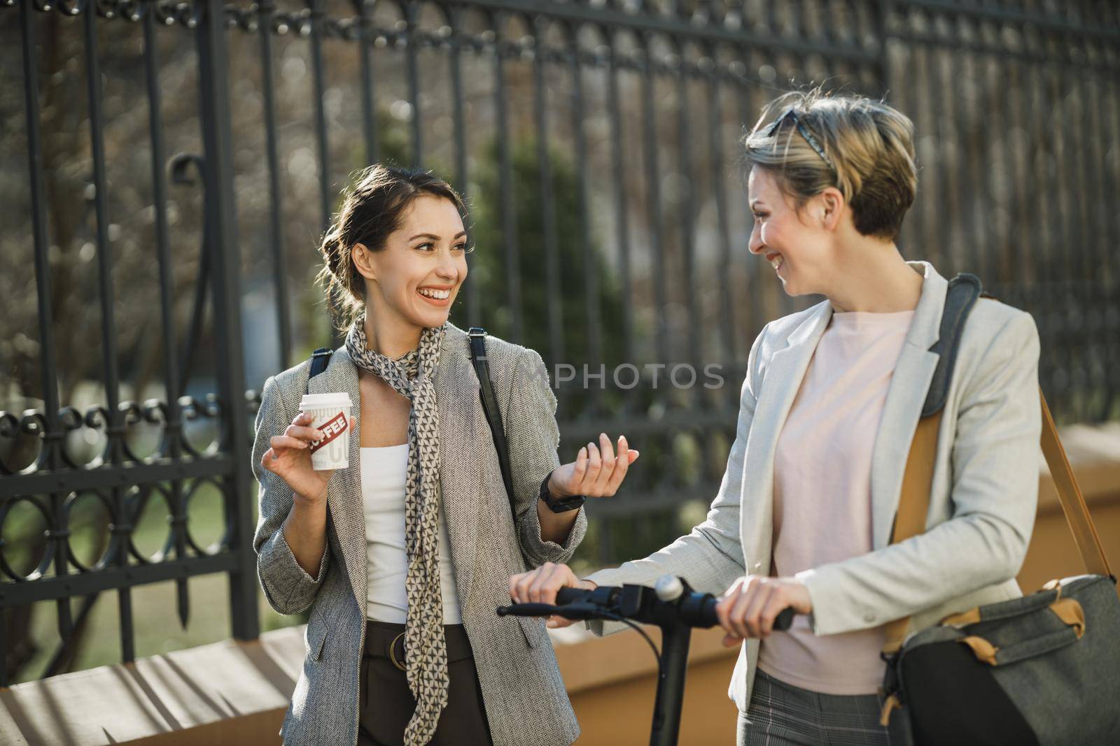 A two successful businesswomen having a quick break and chatting while walking through the city.