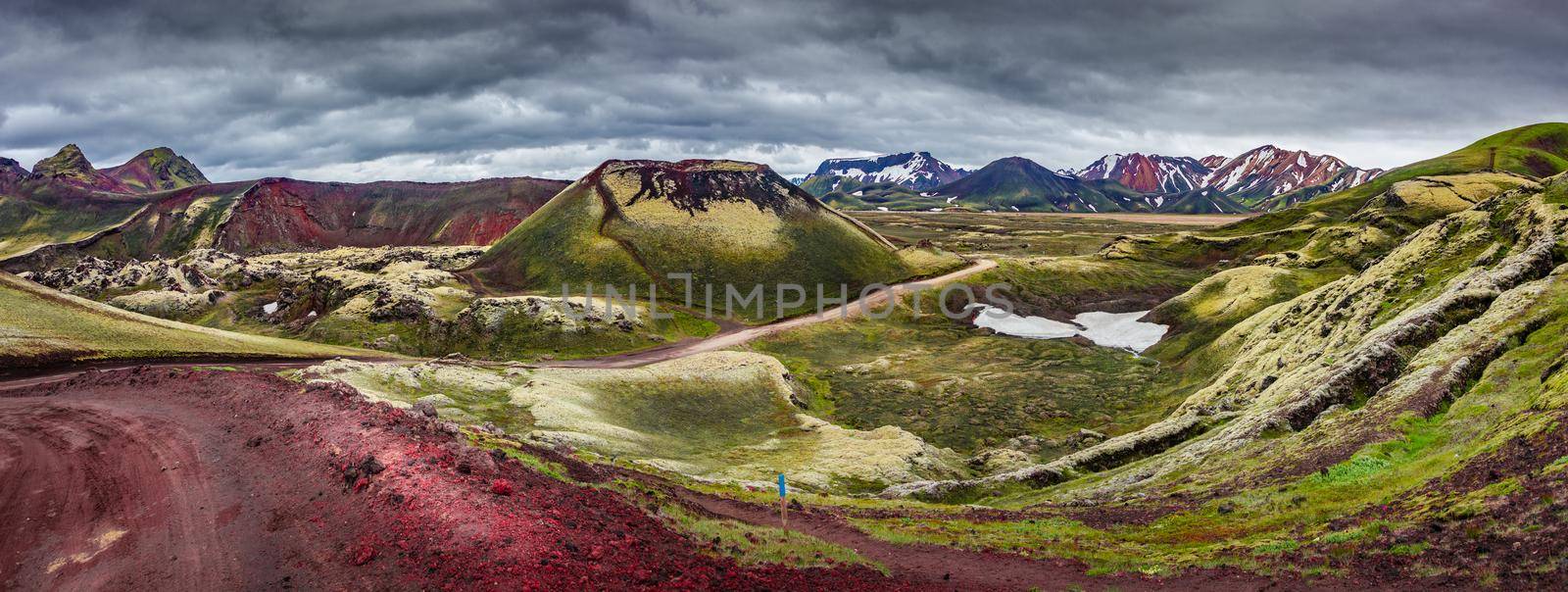 Panoramic unreal magic Icelandic landscape of colorful rainbow volcanic Landmannalaugar mountains, red and pink volcanic crater Stutur at famous Laugavegur hiking trail with dramatic sky, Iceland