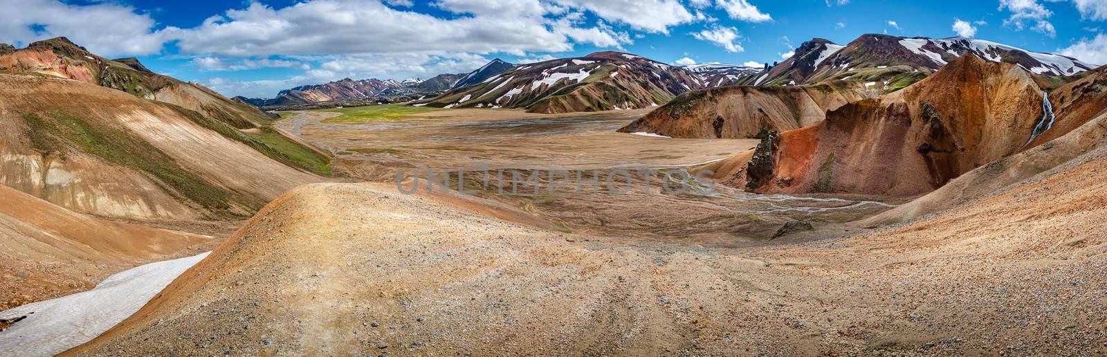 Panoramic true Icelandic landscape view of colorful rainbow volcanic Landmannalaugar mountains, volcanoes, valleys and famous Laugavegur hiking trail at blue sky, Iceland