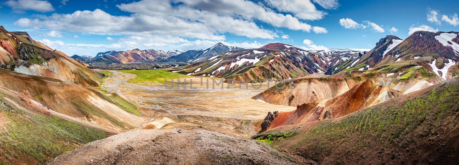 Panoramic true Icelandic landscape view of colorful rainbow volcanic Landmannalaugar mountains, volcanoes, valleys and famous Laugavegur hiking trail at blue sky, Iceland