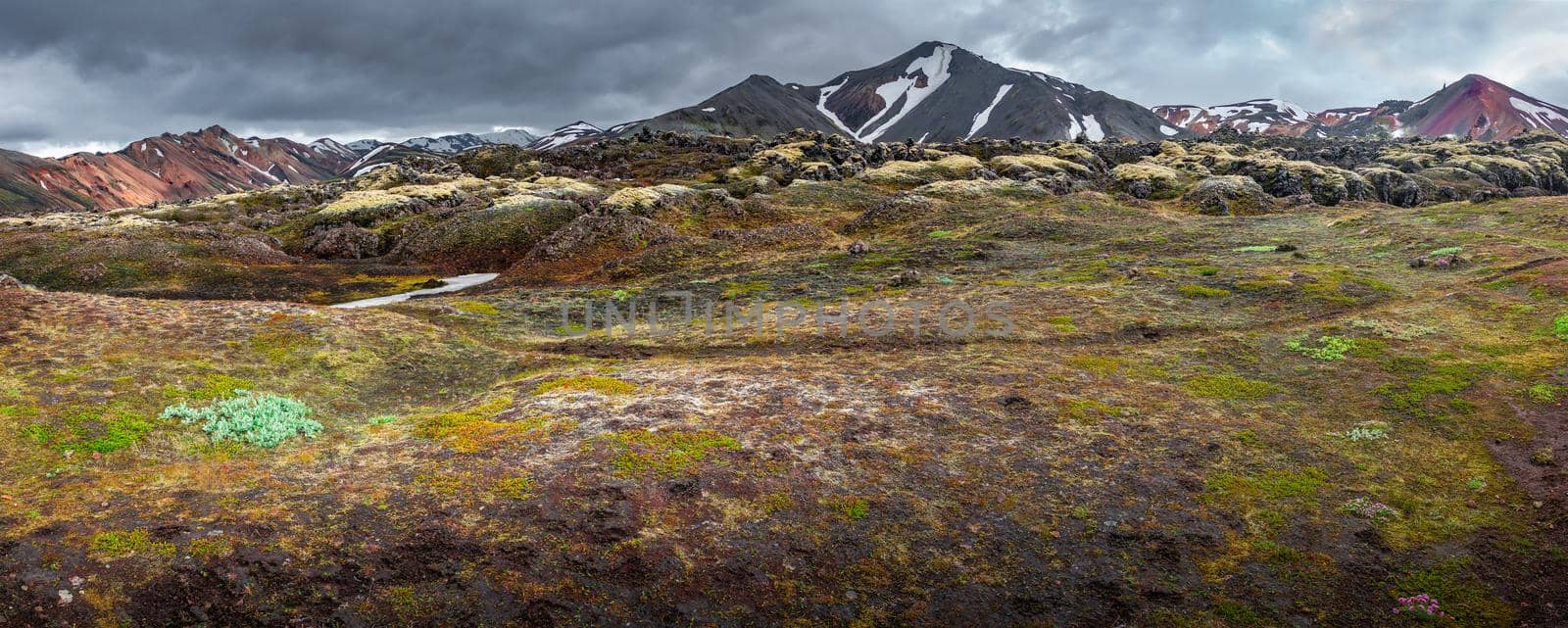 Panoramic landscape view of colorful rainbow volcanic Landmannalaugar mountains and hiking trail path at dramatic sky in Iceland, summer