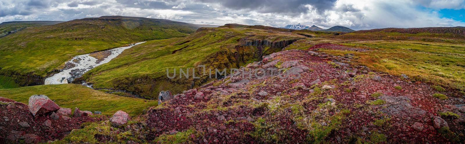 Panoramic view over beautiful colorful Icelandic landscape with Faxi waterfall, ancient moss and lichen, tundra flowers and meadow fields near Snaefell volcano and Laugarfell area in Iceland