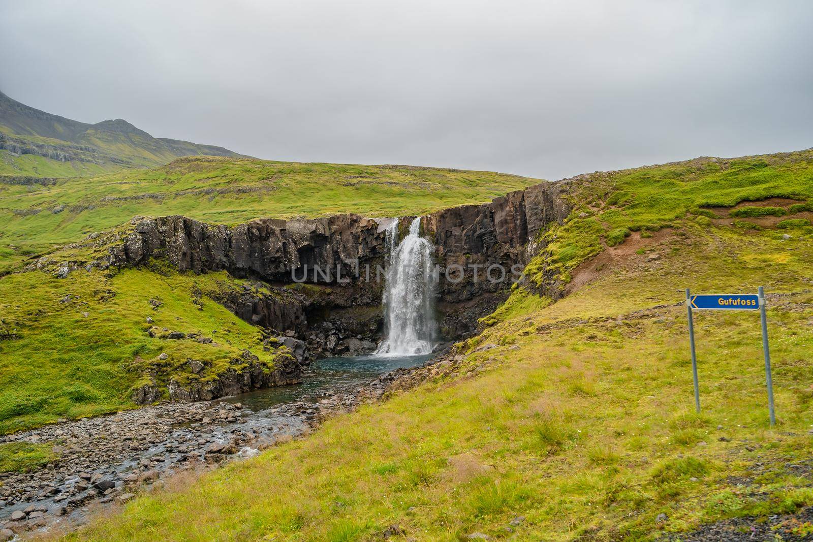 Lonely waterfall called Gufufoss near the road with a sign spelt its name at East Iceland, summer by neurobite