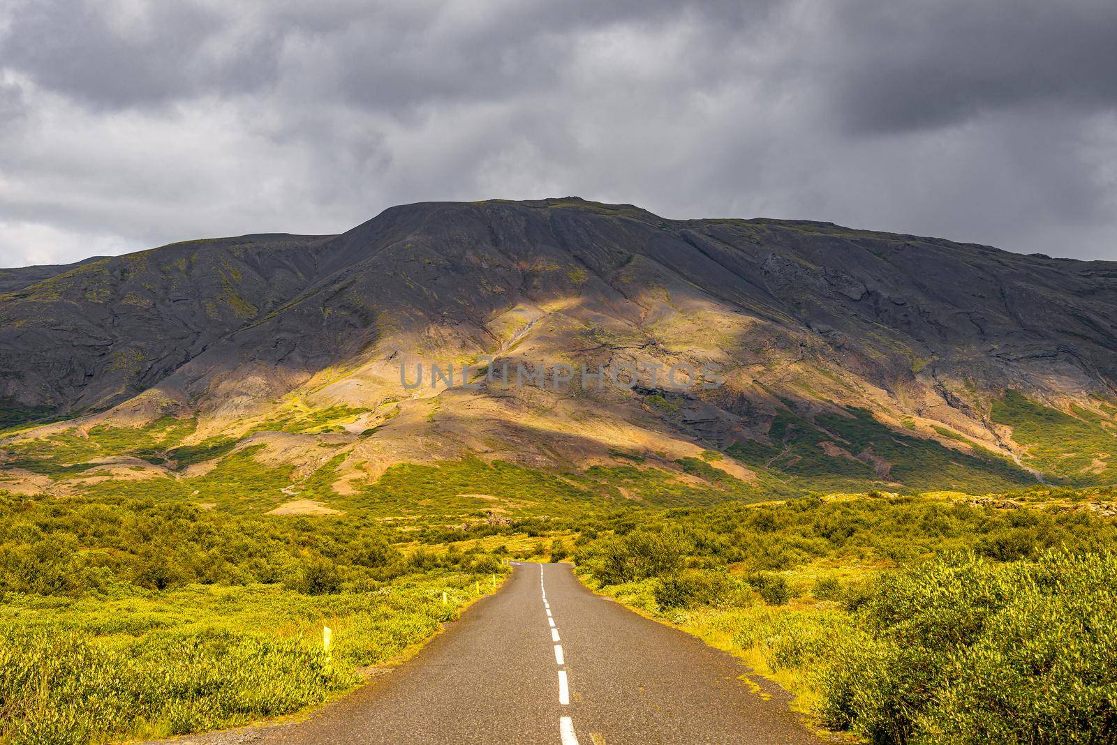 Lonely road through rough and colorful Icelandic landscape, Iceland
