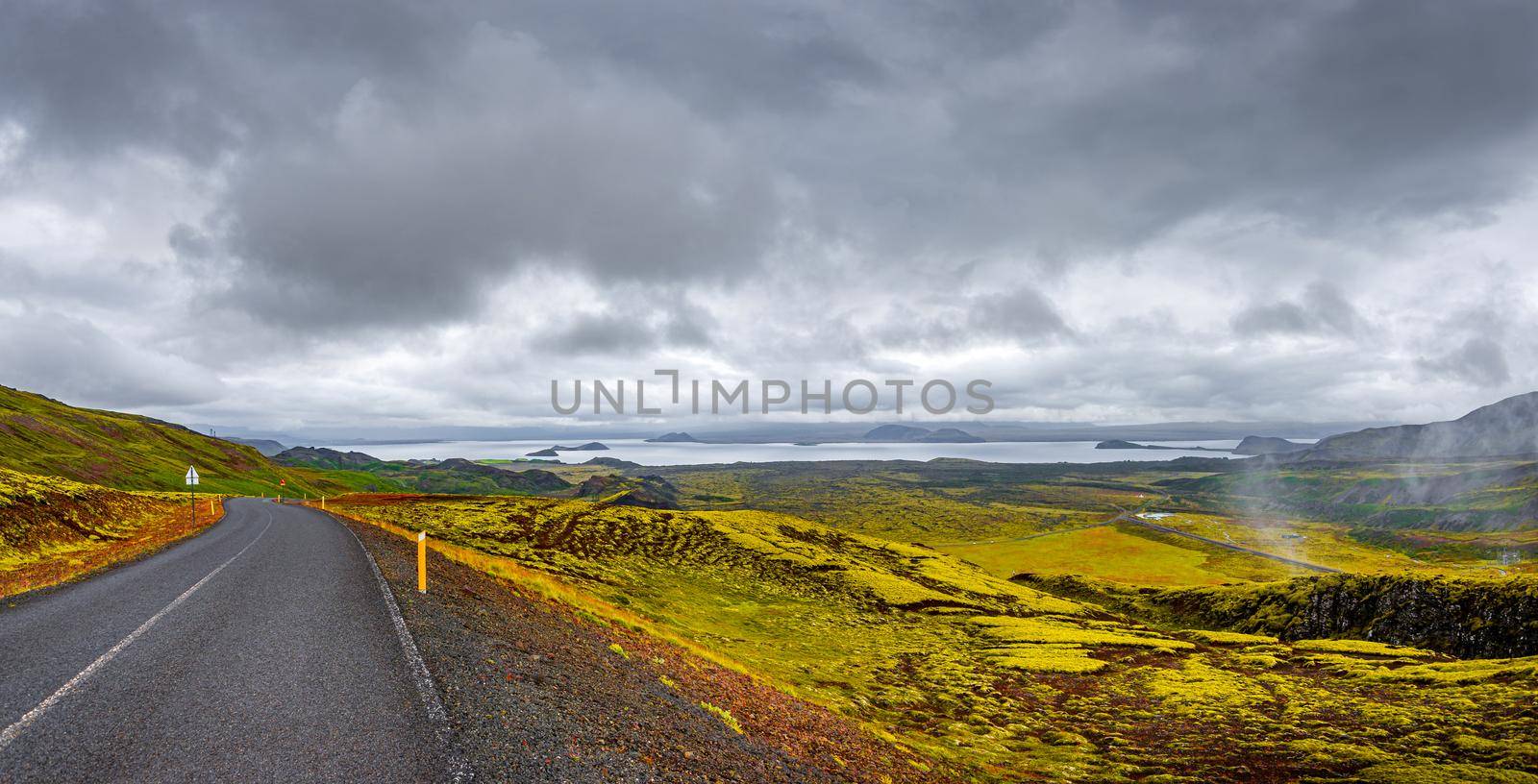 Lonely road through rough and colorful Icelandic landscape, Iceland
