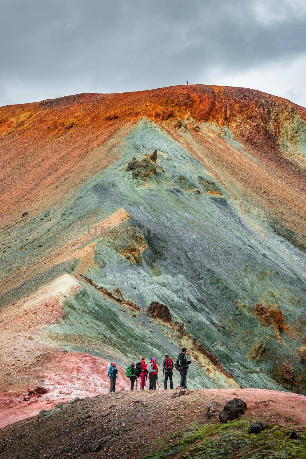 Iconic colorful rainbow volcanic mount Brennisteinsalda in Landmannalaugar mountains and group of hikers in Iceland, summer by neurobite