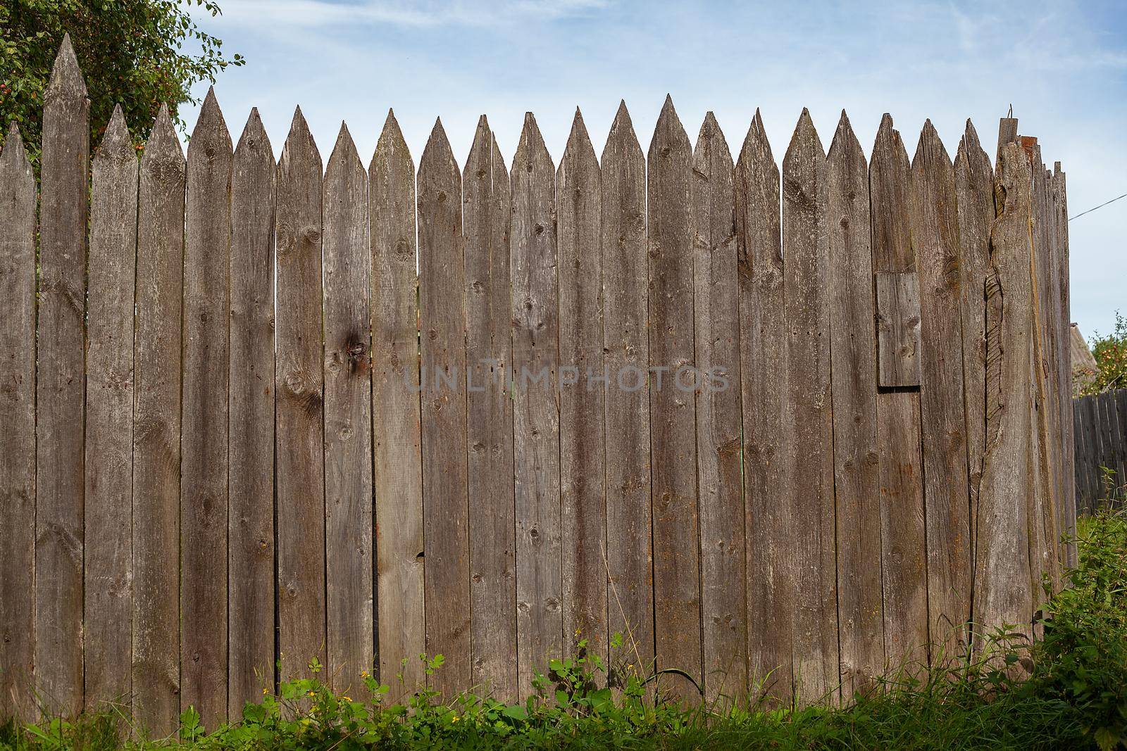 Old wooden fence in the village in summer