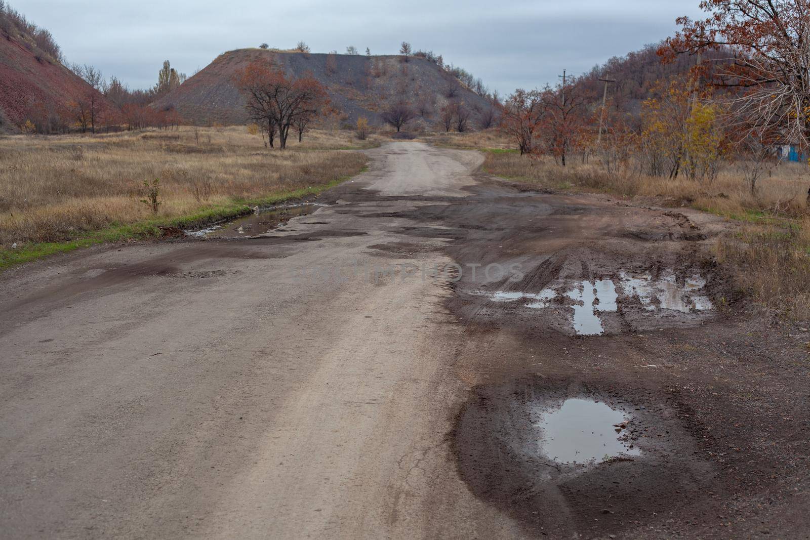 Steppes landscape ath the late autumn with road and slegeheaps