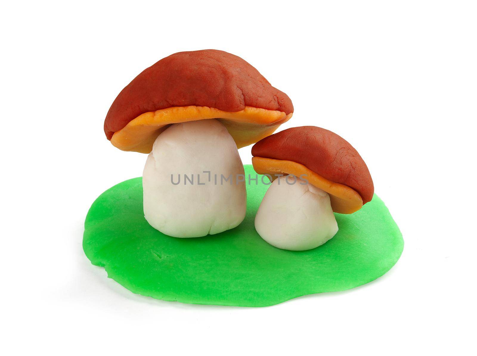 Isoalted plasticine mushrooms and grass on the white background