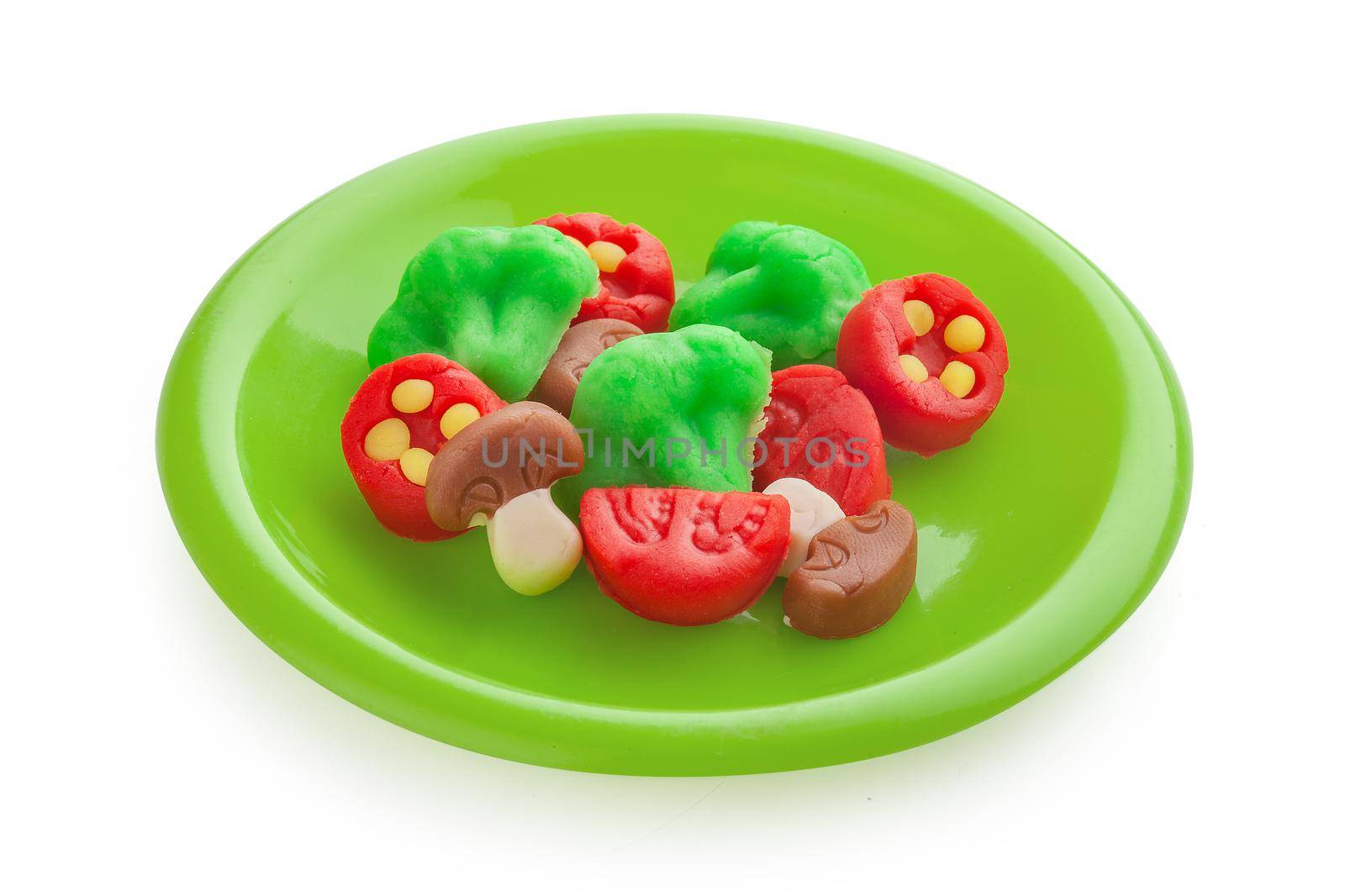 Isolated plasticine vegetables on the plastic plate;