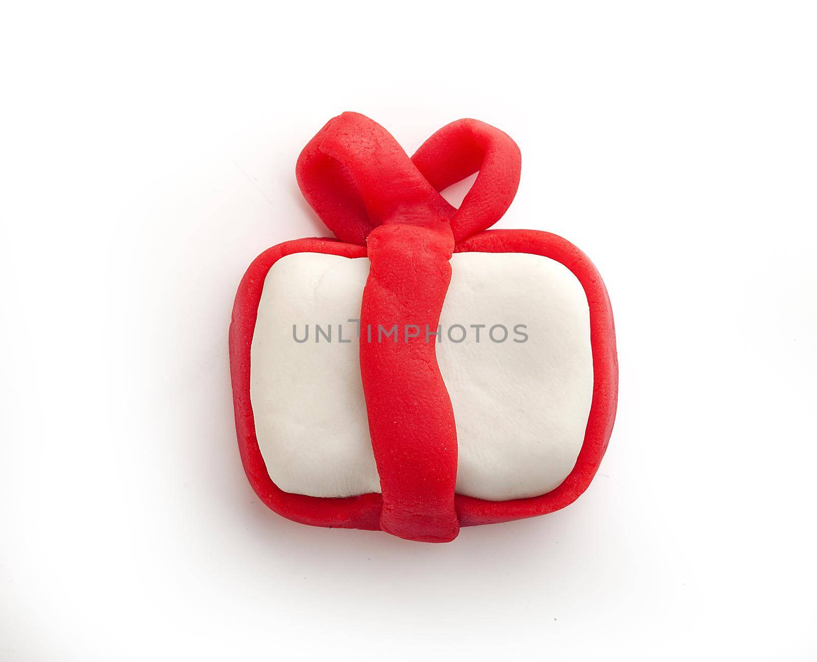 Isolated plasticine gift with red ribbon on the white