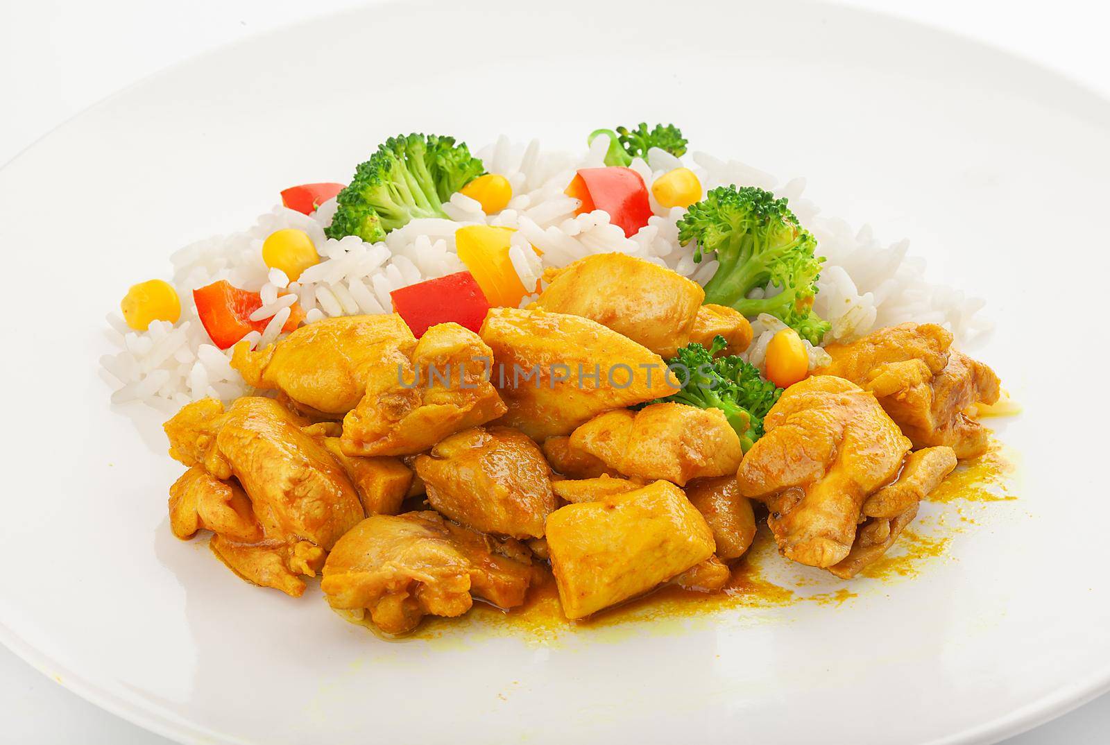 Chicken curry with rice, red pepper, broccoli and corn on the plate