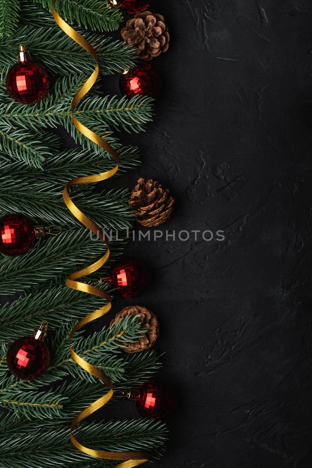 Christmas holidays composition. Golden ribbon, red ornament and bauble decorations, fir-tree and pine cones. Copy space