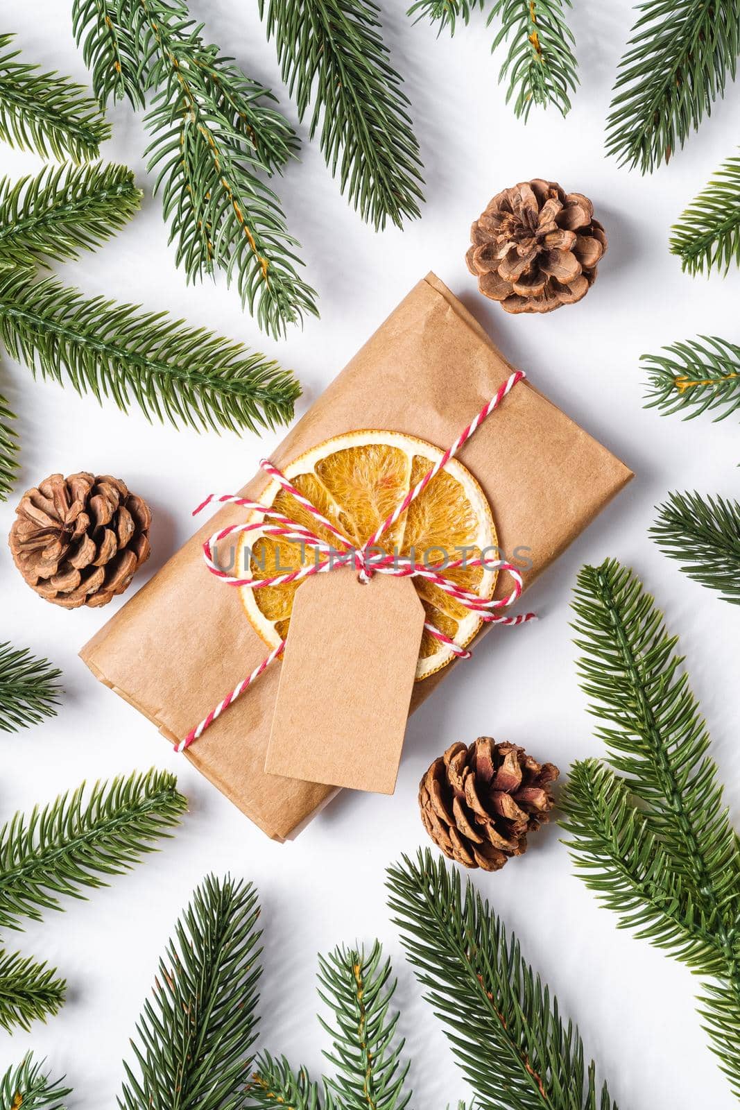 Christmas holidays zero waste paper gift wrapping with tag, dried fruit and fir branches