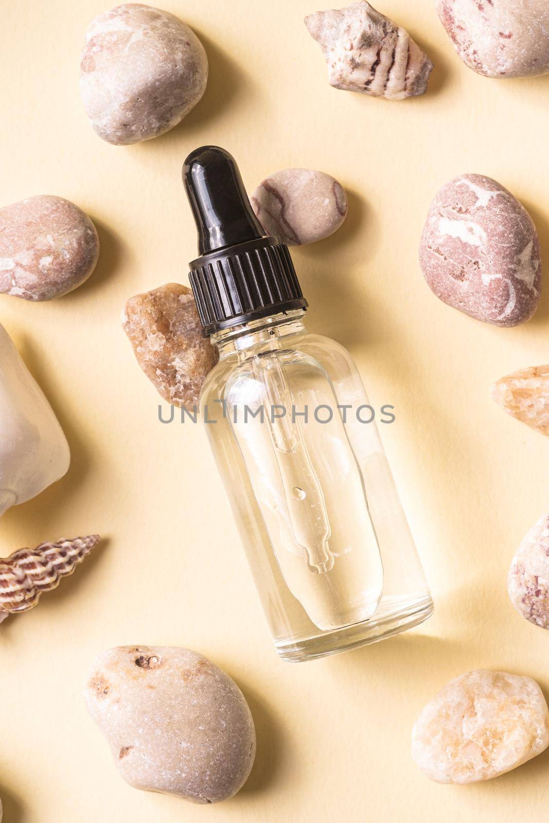 Skin care essence oil dropper in glass bottle on beige background